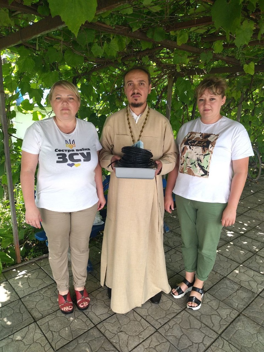 Отець Миколай Олійник разом з волонтерками